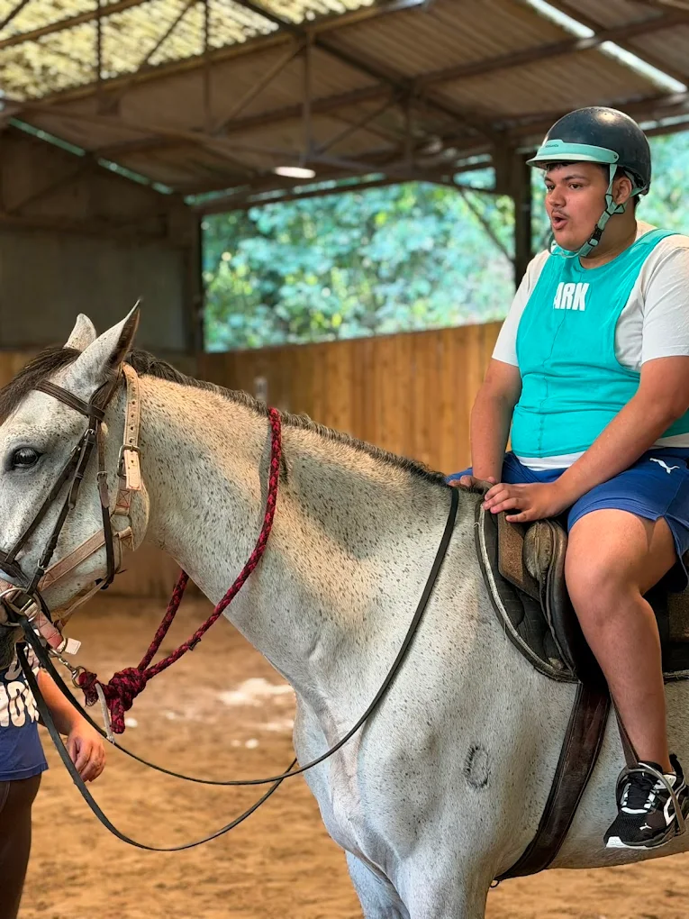 Jeune cavalier accompagné lors d'une séance d'équitation