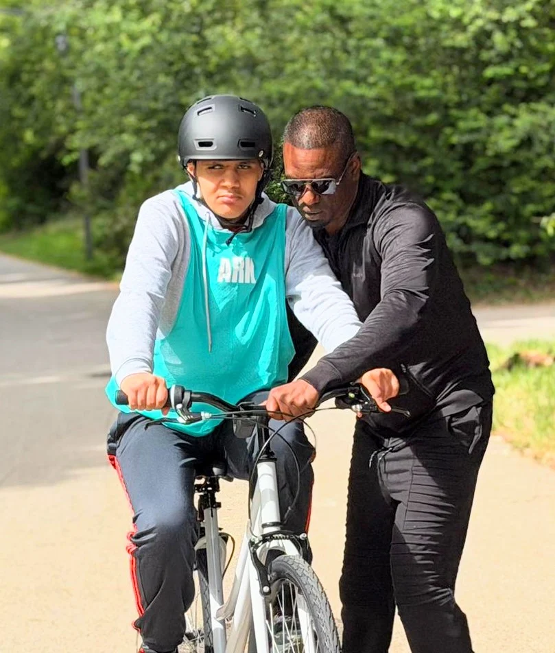 Un jeune accompagné à vélo par un intervenant ARK, dans un cadre sécurisant